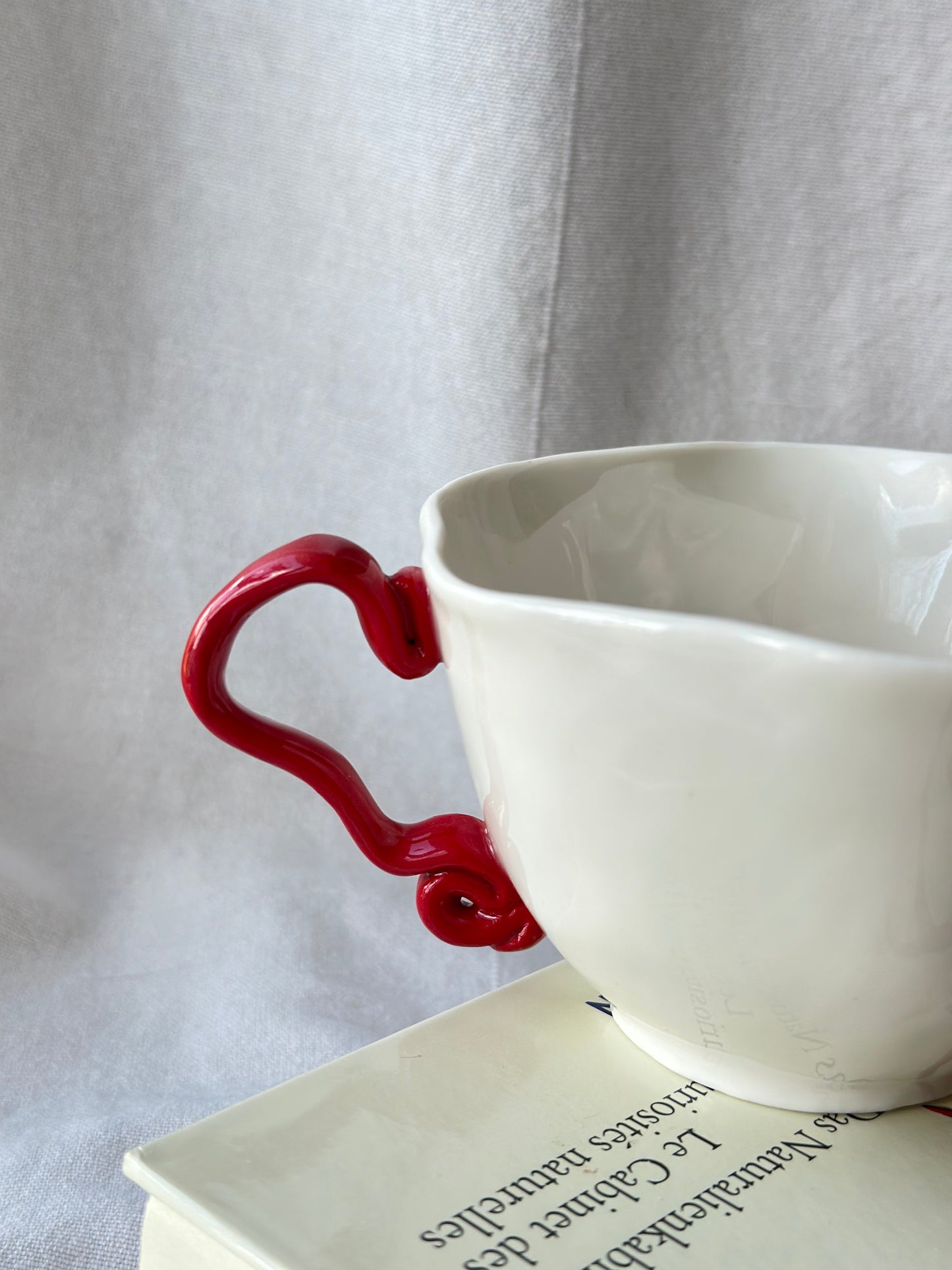 Filiżanka porcelanowa z nietypowym uchem czerwonym