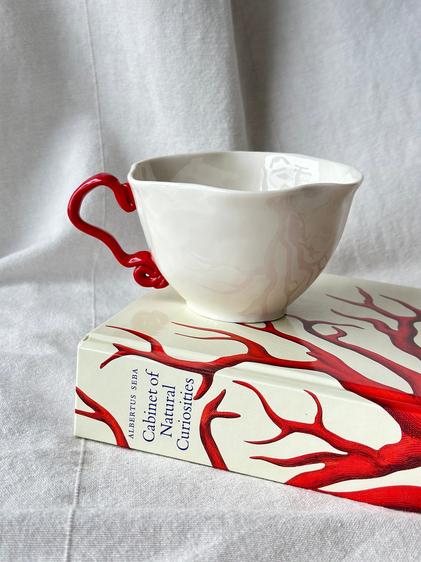 Filiżanka porcelanowa z nietypowym uchem czerwonym