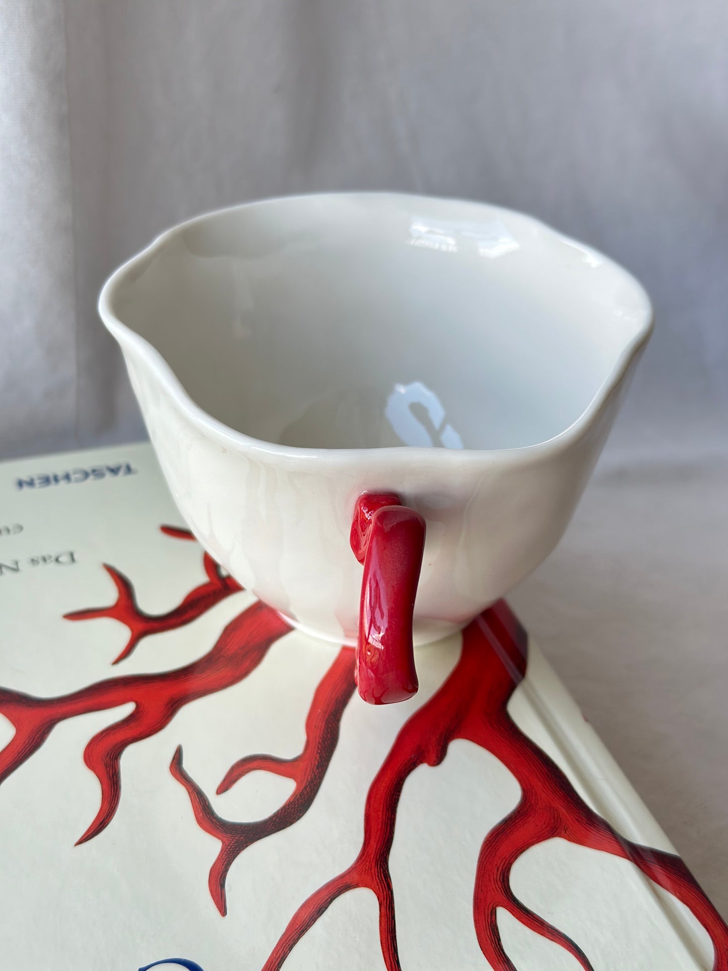 Filiżanka porcelanowa z nietypowym uchem czerwonym