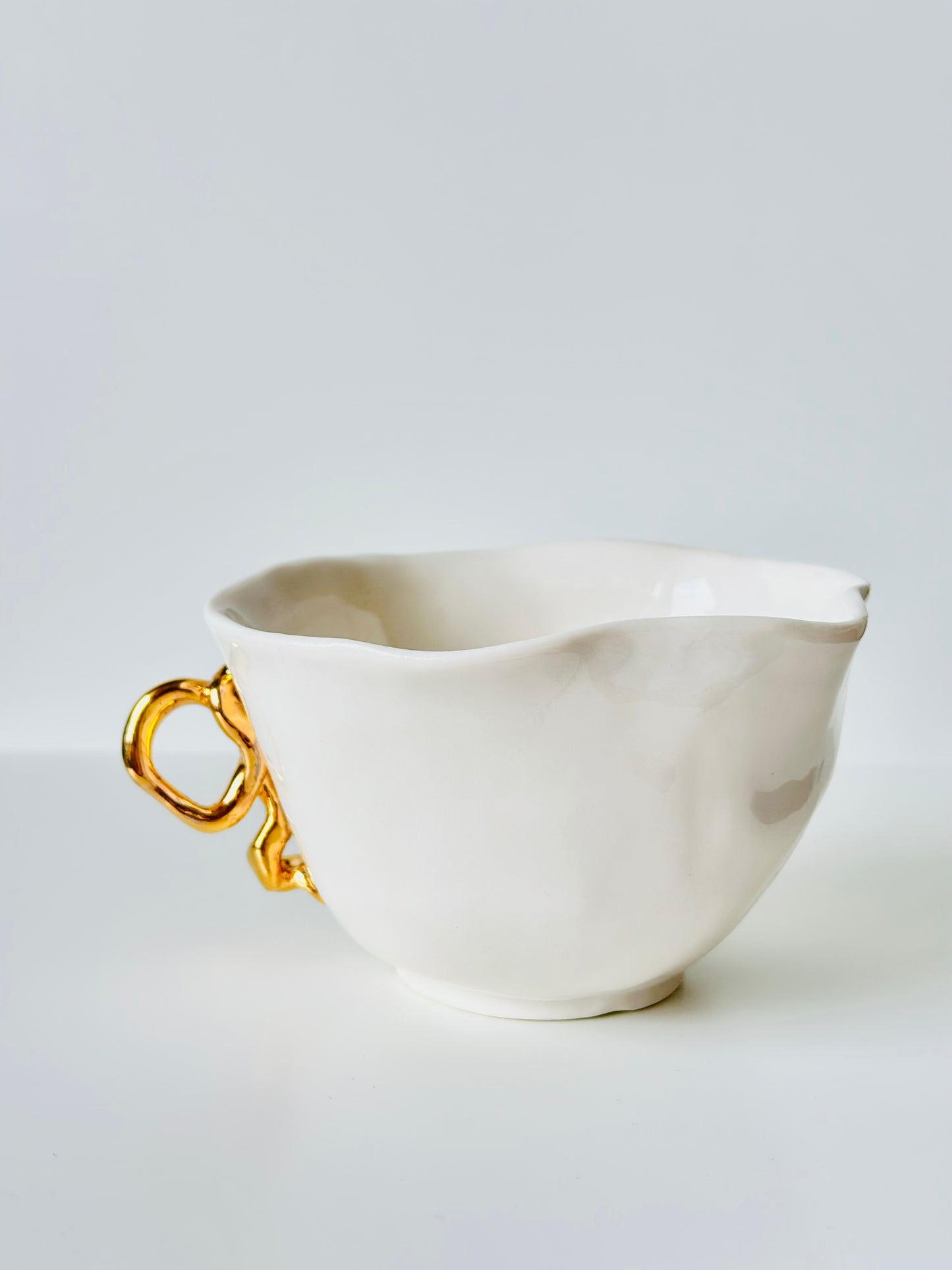 Tasse en porcelaine avec anse dorée