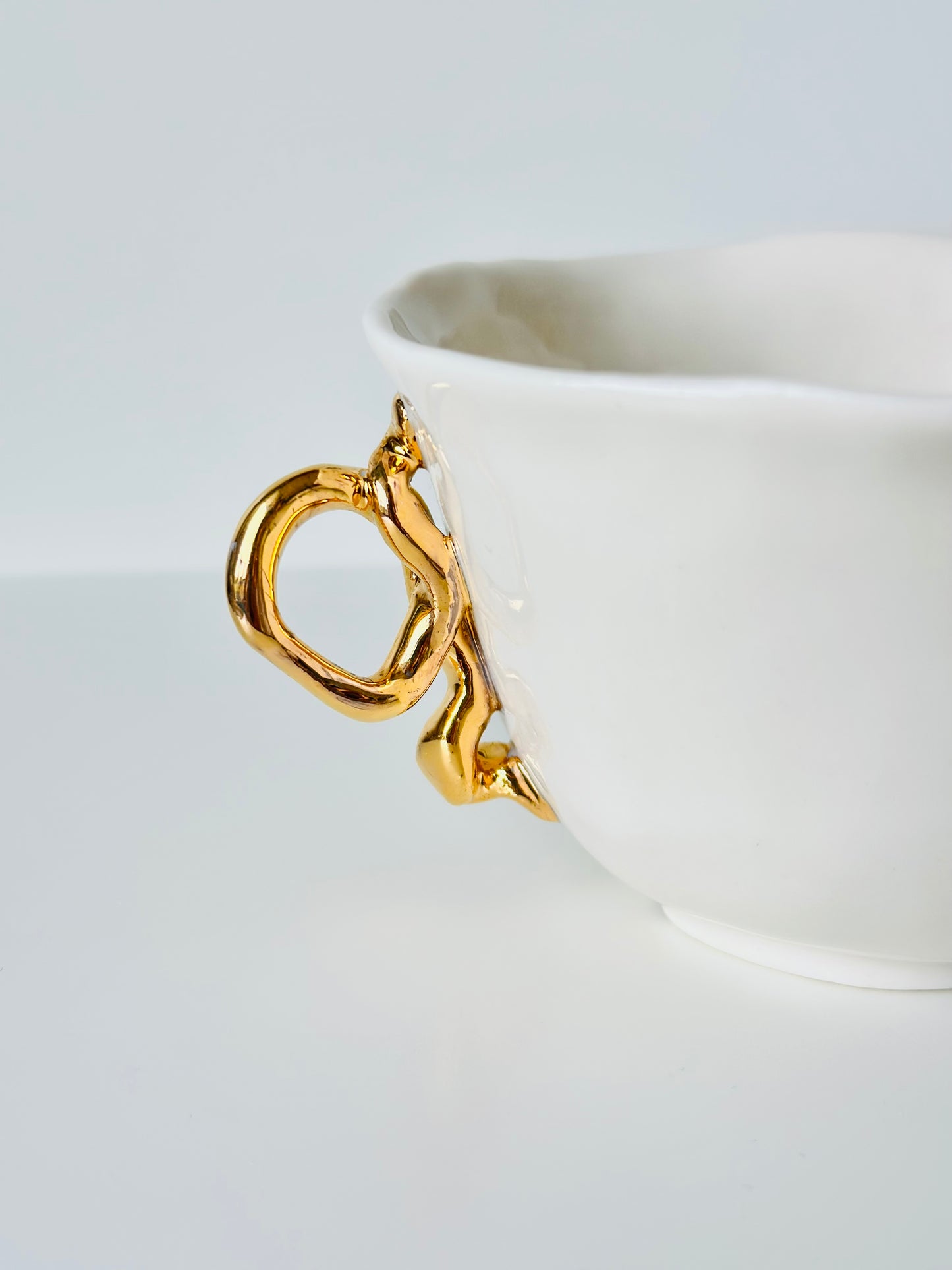 Tasse en porcelaine avec anse dorée