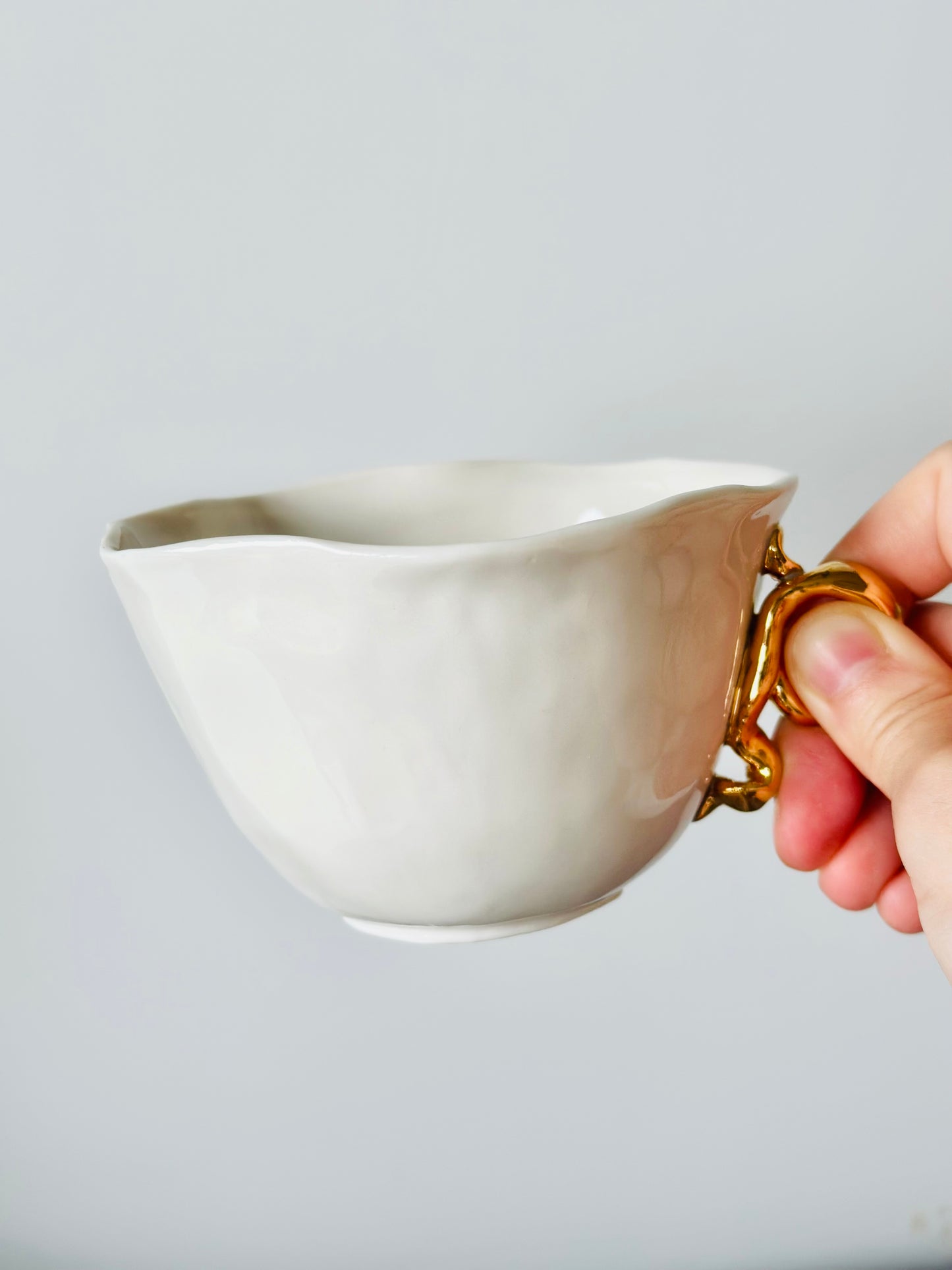 Tasse en porcelaine avec anse dorée