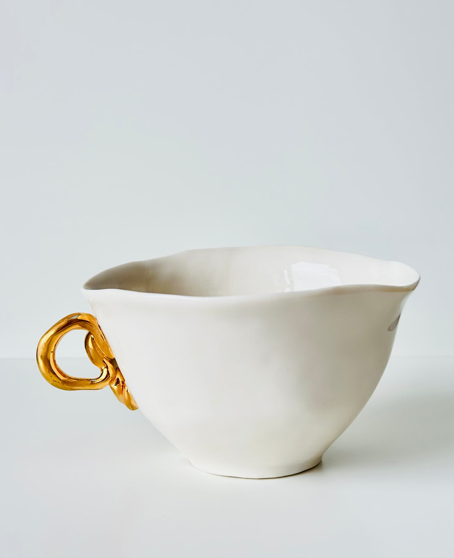 Tasse en porcelaine avec anse dorée