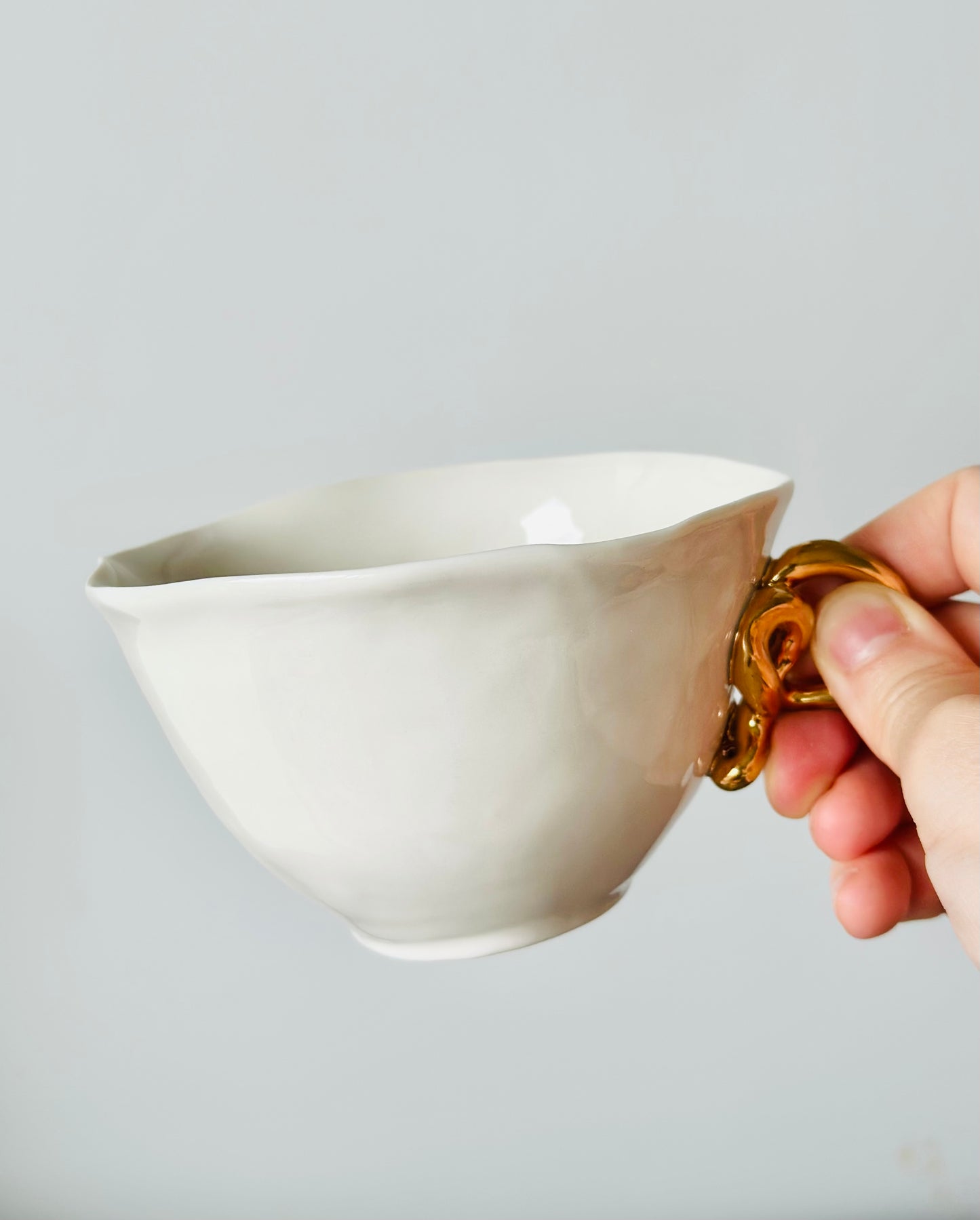 Tasse en porcelaine avec anse dorée