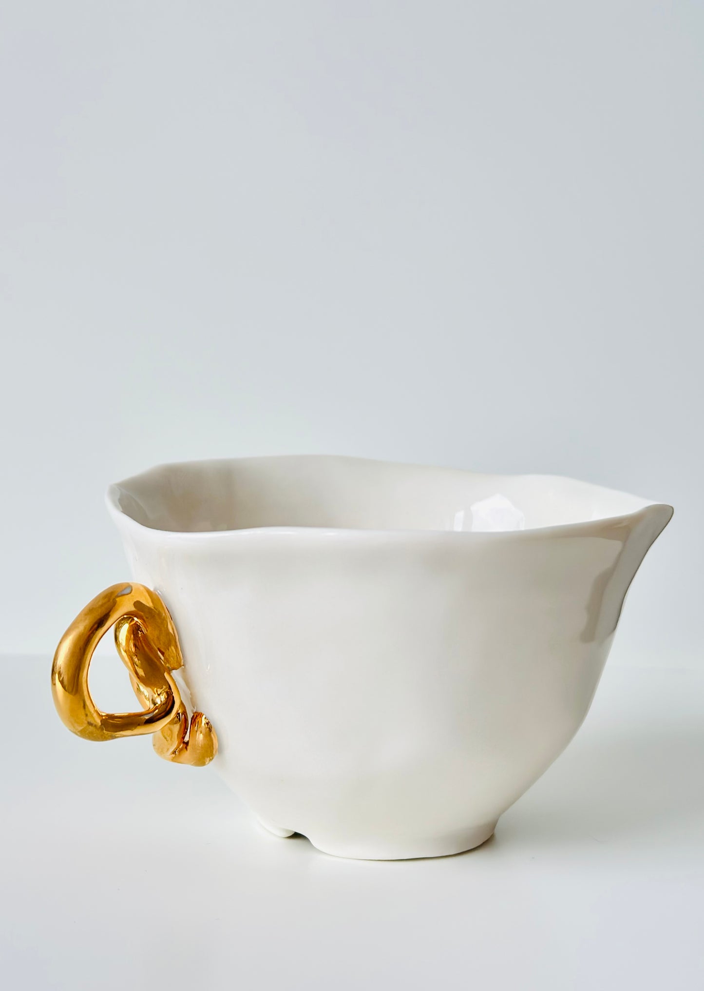 Tasse en porcelaine avec anse dorée