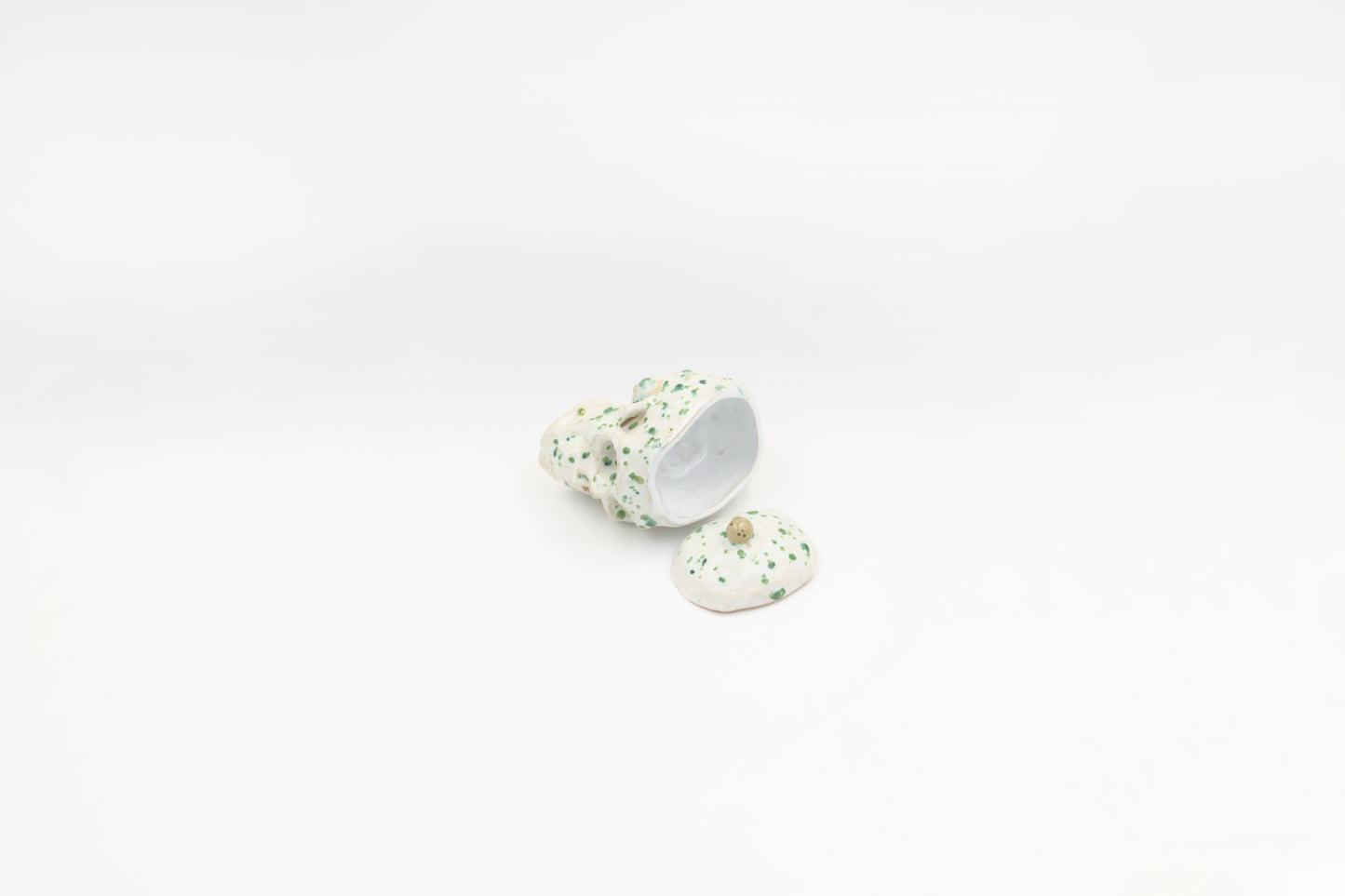 Czaszka-szkatułka w białym kolorze z zielonymi plamkami