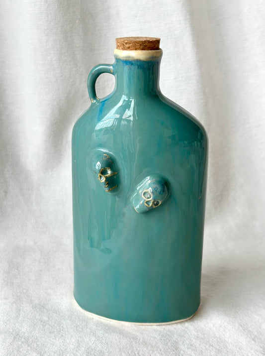 Bouteille/carafe plate turquoise avec têtes de mort