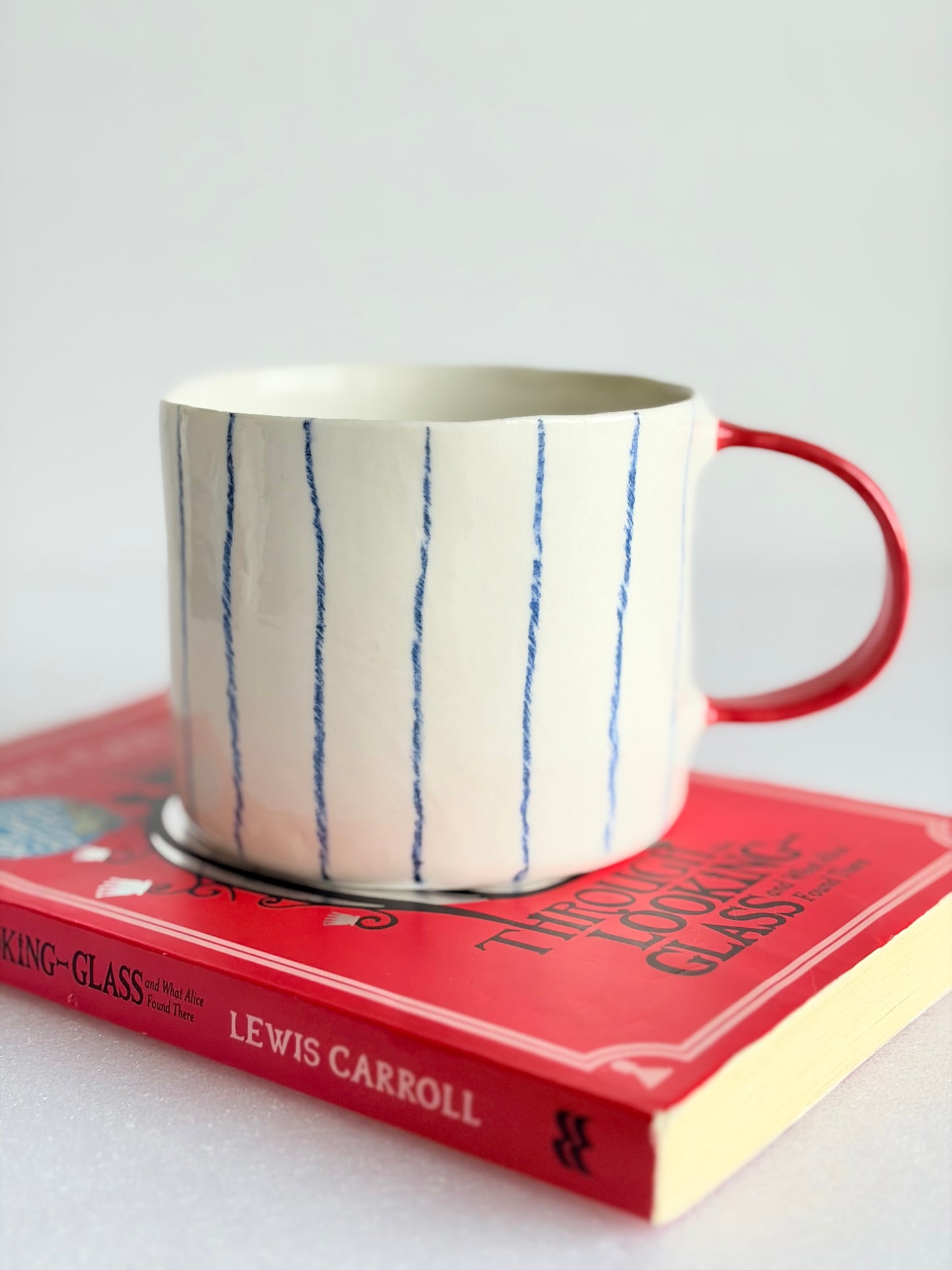 Kubek porcelanowy w pasy z czerwonym uchem